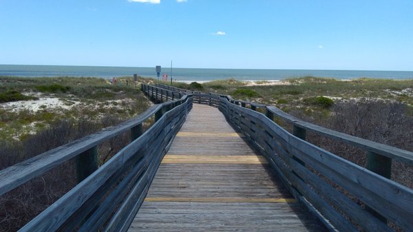 Long boardwalk clean and sturdy. Stroll down to the a beach, so sparkling purdy.