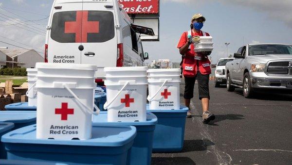 Red Cross volunteer serving meals to persons displaced by Hurricane Laura