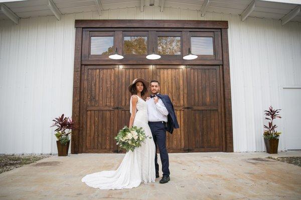 The beautiful custom doors at Cypress Creek Farmhouse are the perfect backdrop for a stunning wedding picture. Dress from Wonderland Bridal