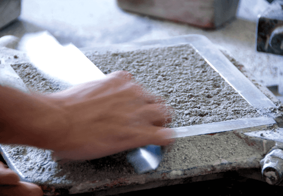 A Spanish artisan works on a hydraulic tile.