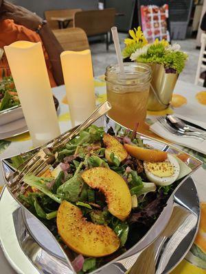 Salad with sliced peaches, pickled onions, and avocados