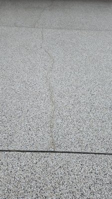 The existing concrete driveway crack reoccurred only one month after  Shark Skin Coating crack repair and new surface coating.