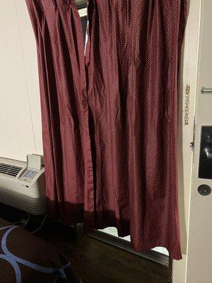 Curtains don't cover window, clipped closed with a pin