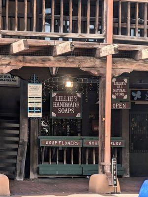 The entrance to Lillie's Handmade Soaps, which has a painted wooden sign and hanging white Christmas lights