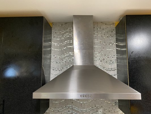 Range hood with design of backsplash tile up to the ceiling