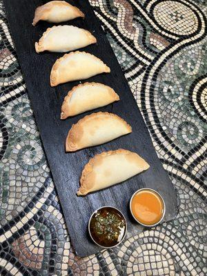 Baked empanadas, chimichurri, and habanero hot sauce.