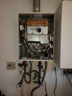 Remove and replace old leaking tankless water heater