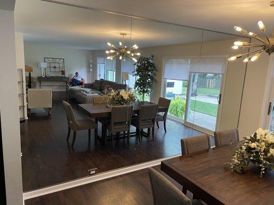 Mirror wall installed to help our customer's dining room and living space feel larger!