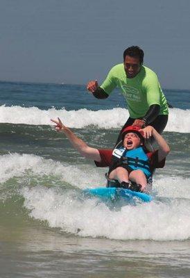 Wheel-chair kid on a surfboard.  Yes!