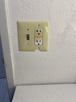 Discolored and broken switch plate in bathroom. More bad painting