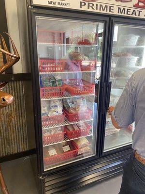 Freezer section with seafood and various things.