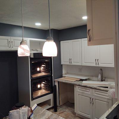 Installing recessed and pendant lighting furring a kitchen remodel.