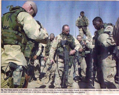 Paul Bunn praying with soldiers in Iraq.