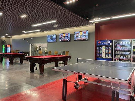 Inside: several TVs, a ping pong table, pool tables and vending machines