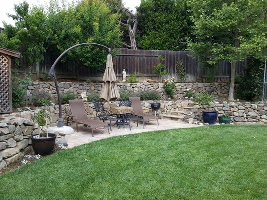 Backyard landscape with retaining wall and leisure area