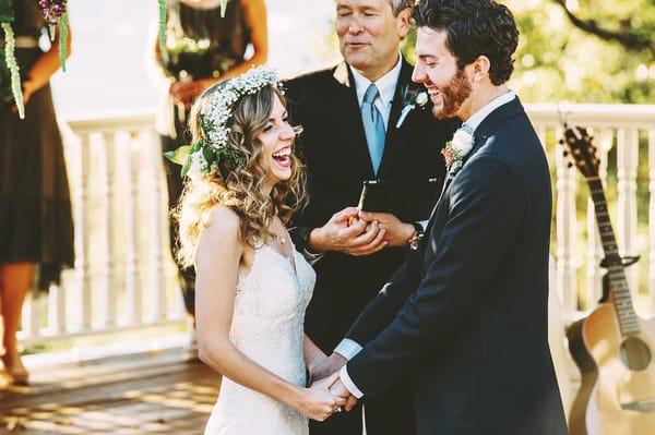 Daniel and Mary Beth laughing before their first kiss after her veil flies off into the guest.