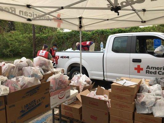 Red Cross volunteers distribute food to persons affected by Hurricane Laura