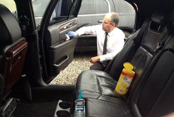 Redlands Chauffeur Larry cleans our Town Car after passengers during the covid-19 crisis.