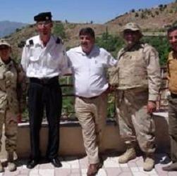 Pic­tured: Cap­tain Steve Had­dad (second from right) with mem­bers of his unit and some loc­als in Ir­aq.