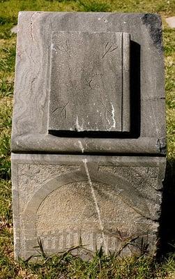 Unmarked headstone depicting the Gate of Heaven and a closed book.