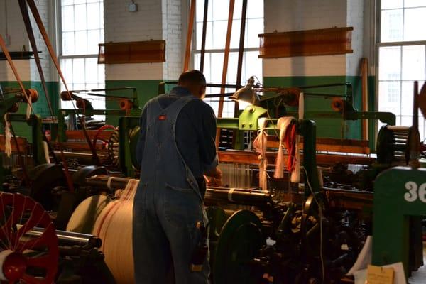 worker over looking power loom