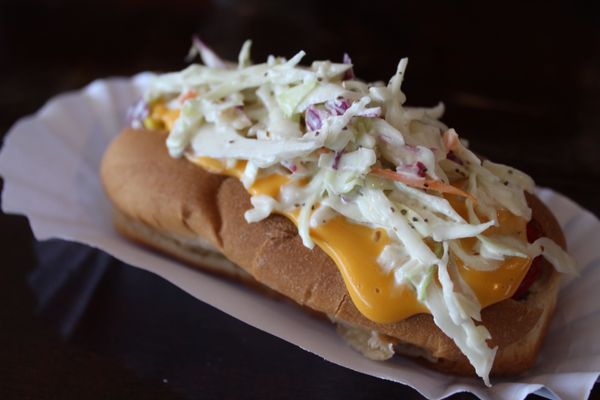 Cheese sauce and coleslaw on a hot dog