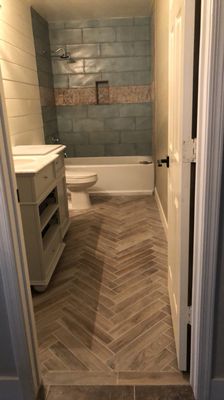 Herringbone floor, tile shower & shiplap