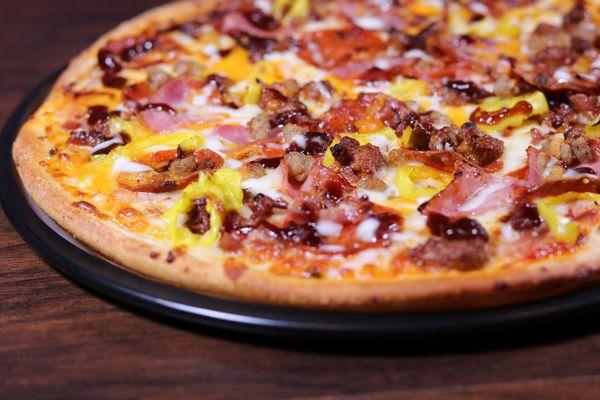 Voodoo Pizza -Pepperoni, sausage, ham, ground beef, bacon, banana peppers. Drizzled with BBQ and Ranch Sauce. Topped off with cheddar cheese