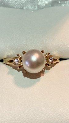 Stunning cream colored pearl set into gold ring with diamond accents