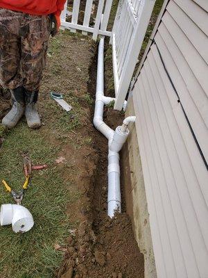 Sump pump discharge and gutters are attached to a pop-up away from the house.