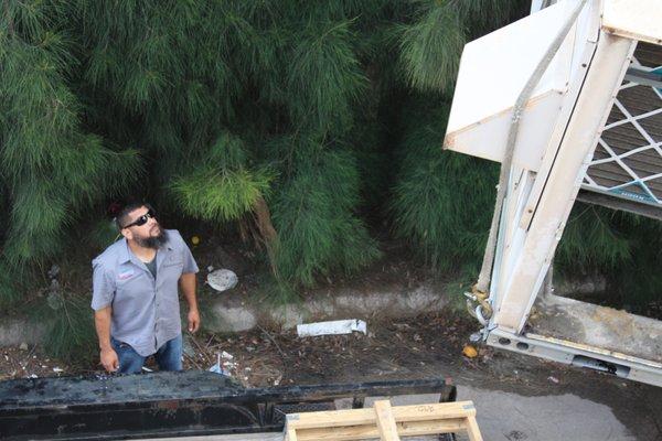 Benny is waiting by the trailer to receive the old unit, load it onto the trailer, and dispose of it properly.