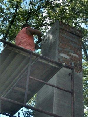 Application of cement scratch coat before new stucco applied.