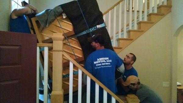 Putting the piano back in the upright position to finish carrying it down the stairs.