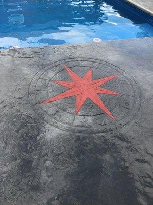 Stamped Compass Rose on a concrete pool deck; rose is highlighted in color.