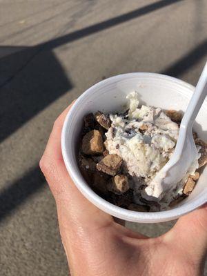 A scoop of moose tracks ice cream with peanut butter cups.