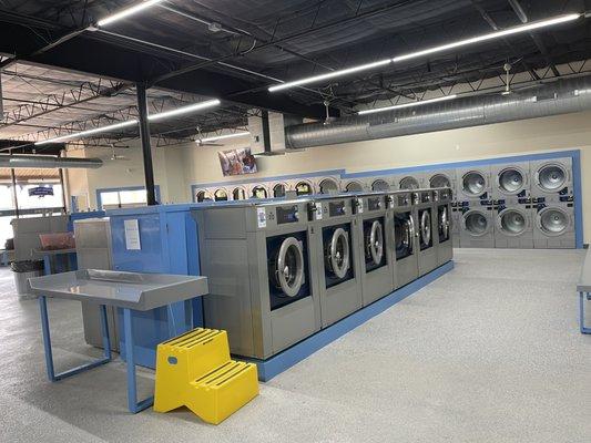 Medium sized washers in front and medium sized dryers in back