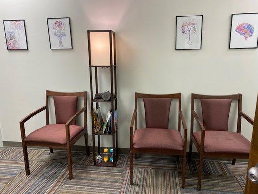 Waiting room with red chairs and brain art.