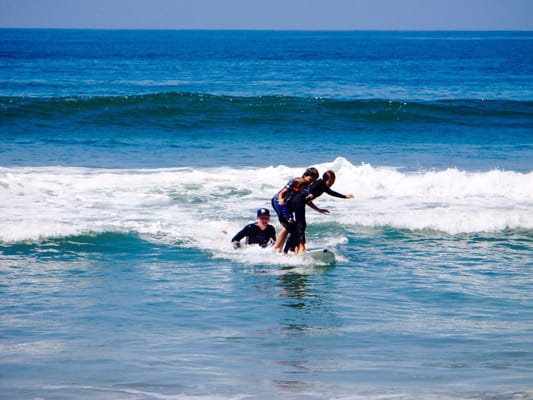 They are having a blast tandem surfing