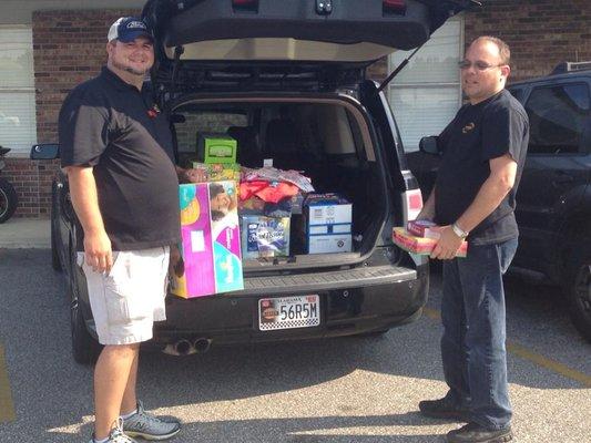 Doug and Brian loading up the school donations the guys bought.