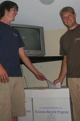 Denny and Brandon posing in front of the recycle box