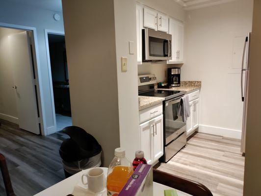 Kitchen with stove, oven, microwave, coffee pot.