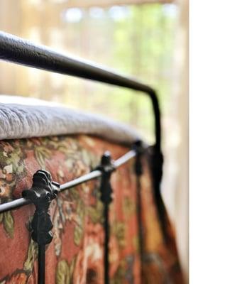 detail of antique iron bedframe in sunroom