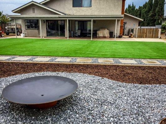 This yard incorporates a modern design.  It was design with entertainment in mind while reducing maintenance cost for this busy home owner.