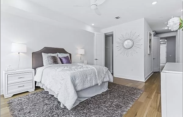 Master bedroom staged with a neutral contemporary design in a new construction four bedroom townhome.