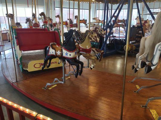 A row of 3 miniature jumpers for little kids, while the rest of the carousel has 2 larger horses per row.