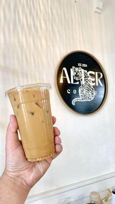 Vanilla iced coffee with the new Alter Coffee sign and logo.