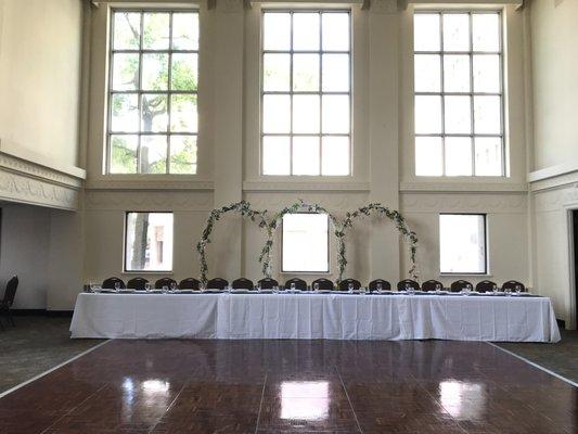 Grand two story windows showcase an exquisite head table.