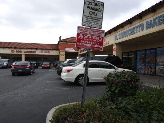 Tow company signs posted in the lot.  This blank corner spot is where my vehicle was towed from.  $308