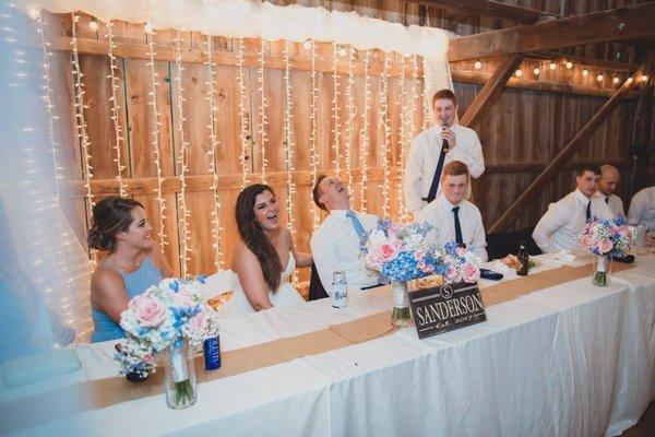 Toasting to the bride and groom at their wedding reception in the barn