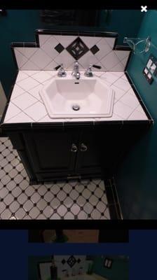 Deco style sink in custom cabinetry featuring original arts and crafts central tile piece.